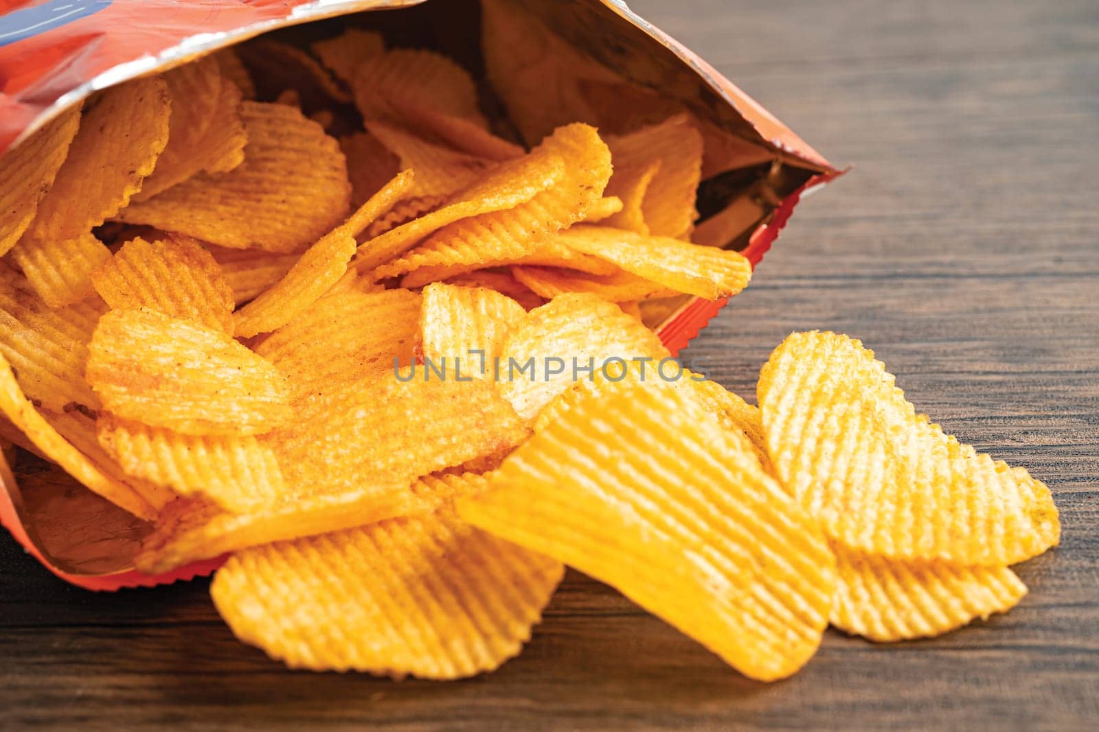 Potato chips, delicious BBQ seasoning spicy for crips, thin slice deep fried snack fast food in open bag. by pamai