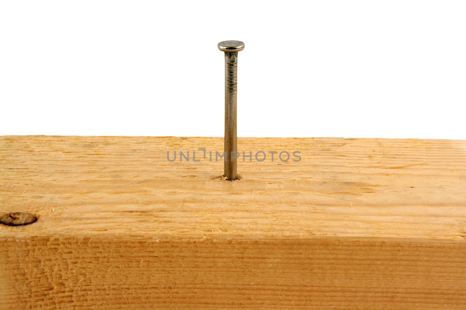A Ten penny nail in a peice of wood