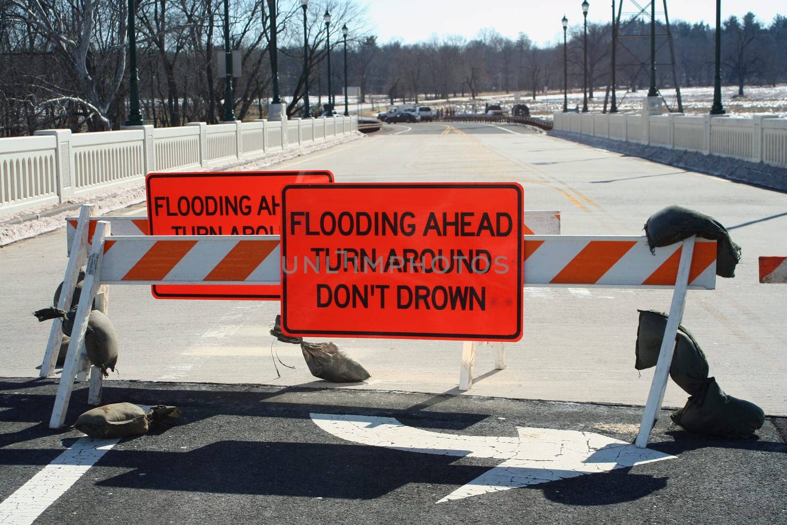 A Flooded roadway sign on a bridge