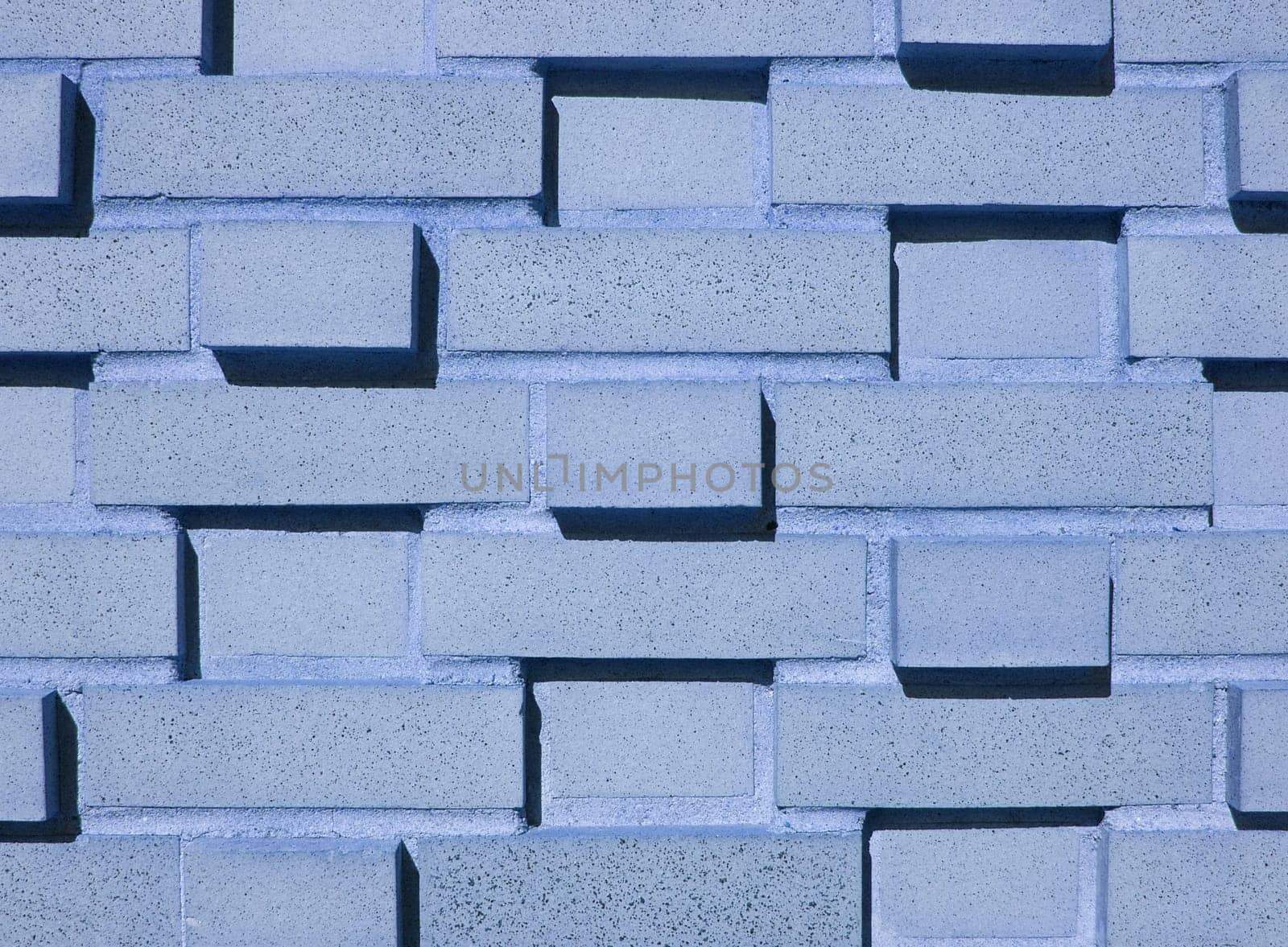 A pastel blue multi-layered and multi-sized brick wall.