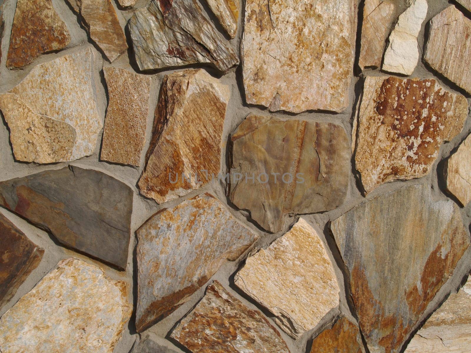 Close-up of Multi-colored flat stone facade on a building.