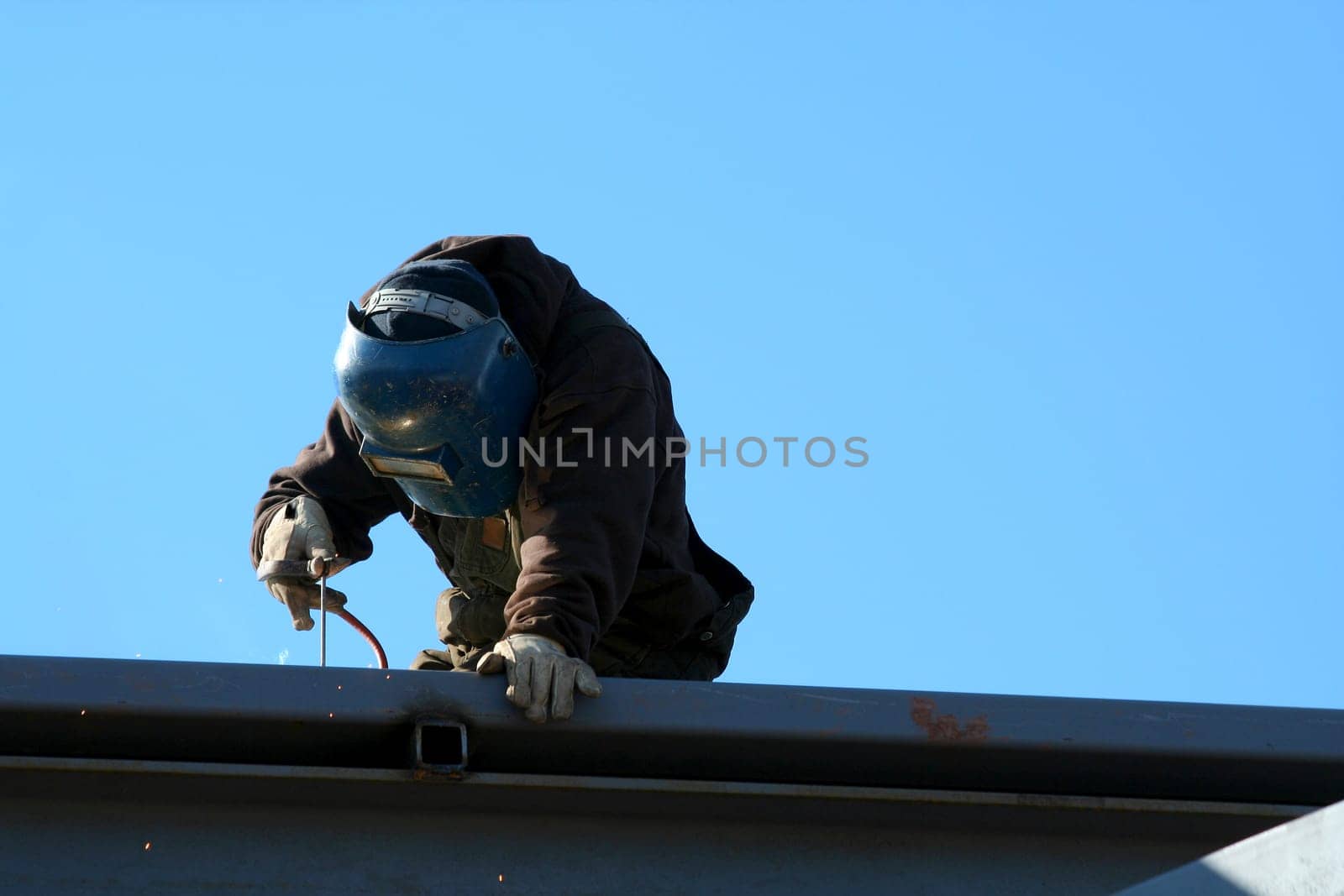 A welder on the roof of a construction site