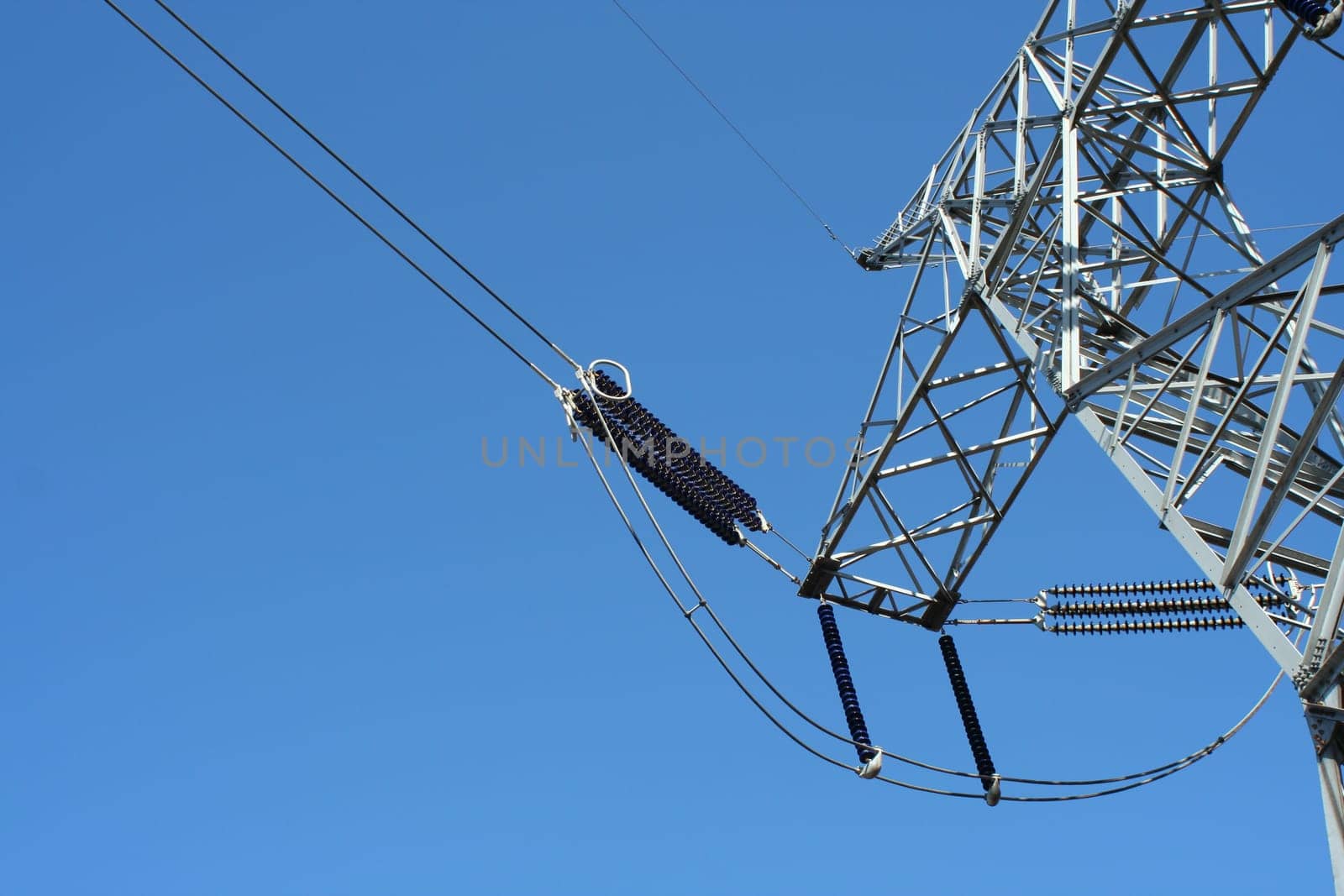Power line tower against blue sky