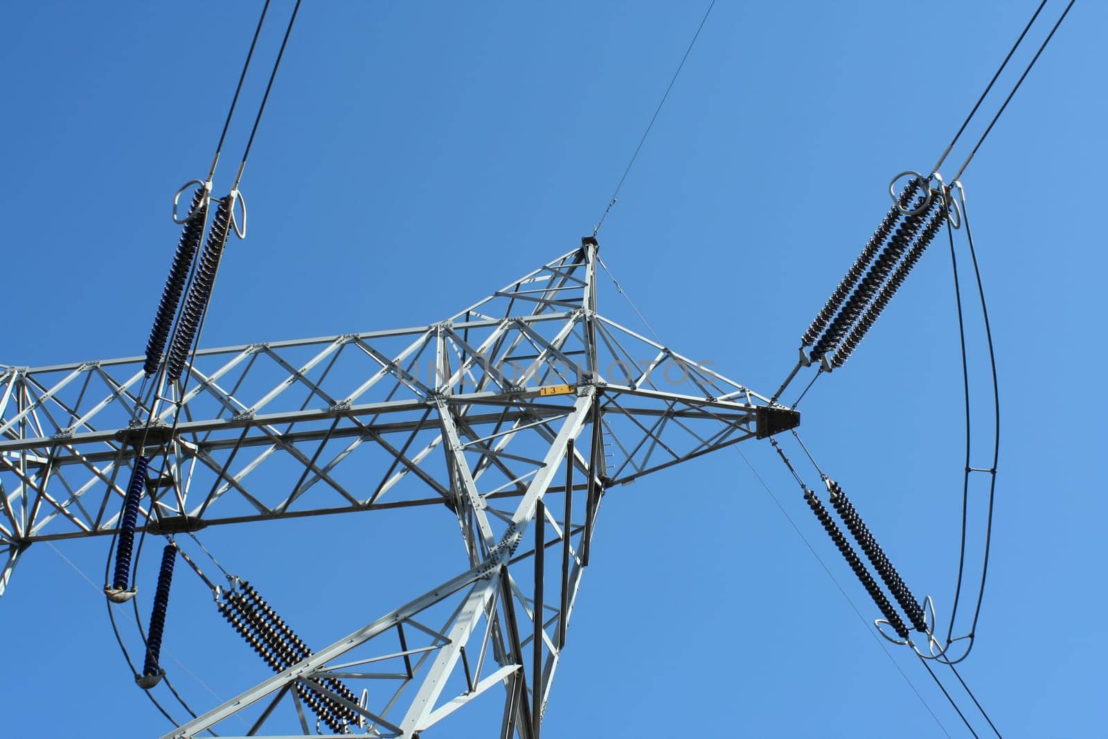 Power line tower against blue sky