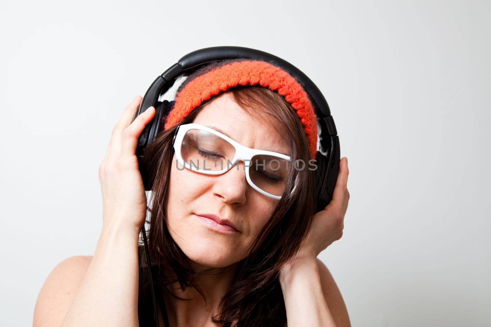 Young woman listening music with headphones. Studio shot.