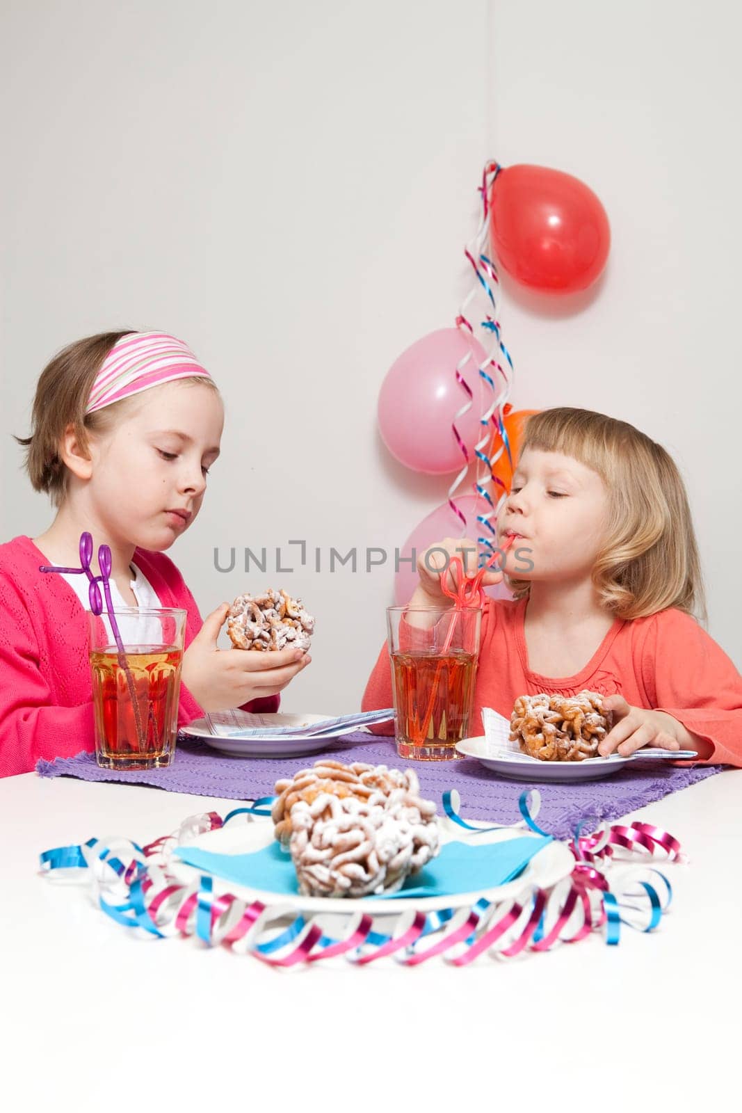 Girls having a traditional finnish May Day celebration, eating funnel cake, tippaleipa and drinking mead, sima