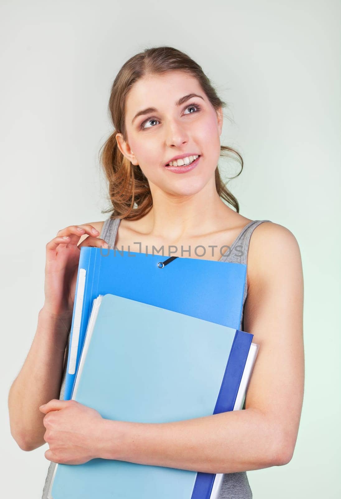 Pretty teenager girl holding blue plastic folders