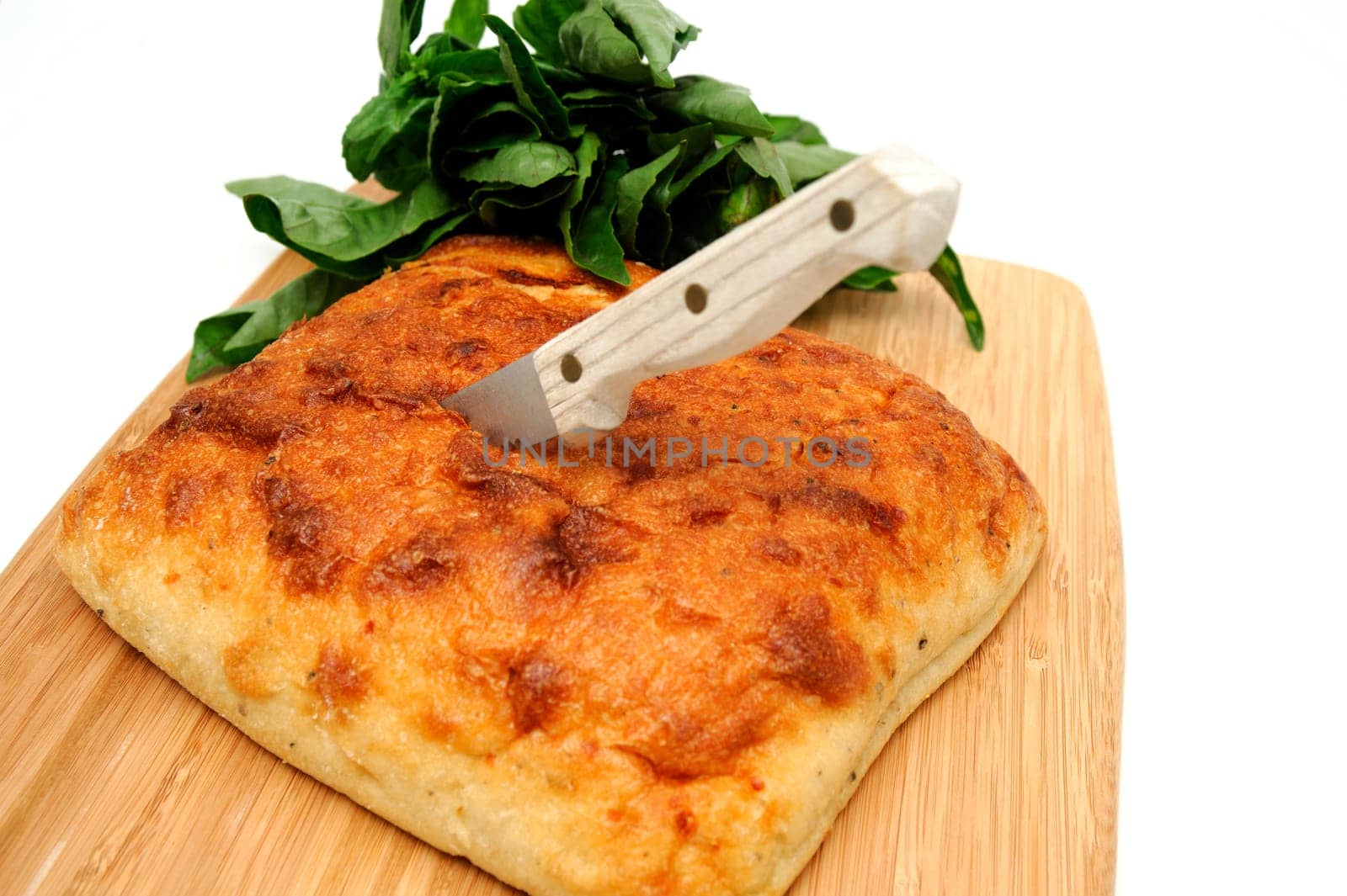 A square loaf of artisan bread ready to be sliced on a wooden cutting board