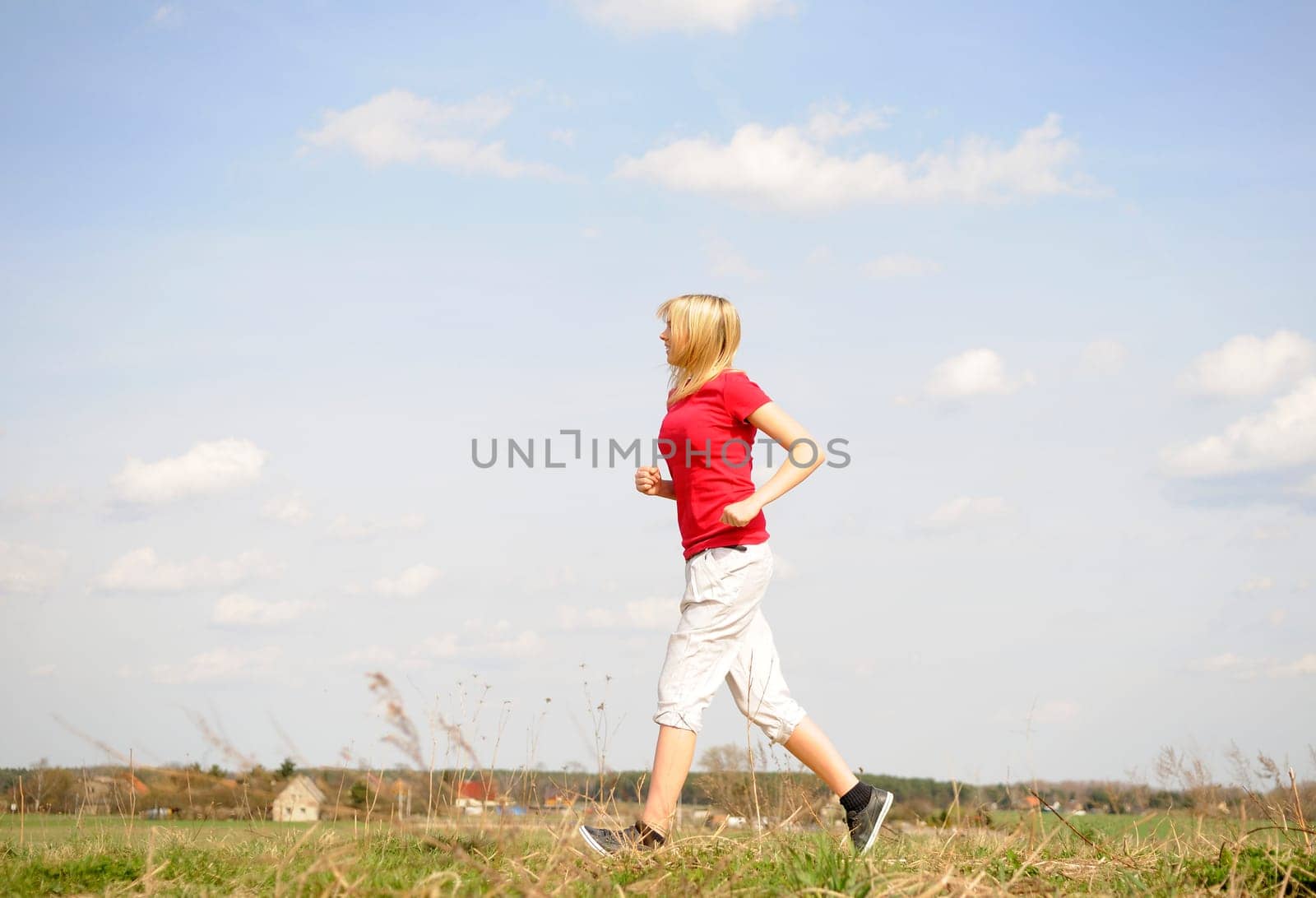 Young woman jogging on a dirt road