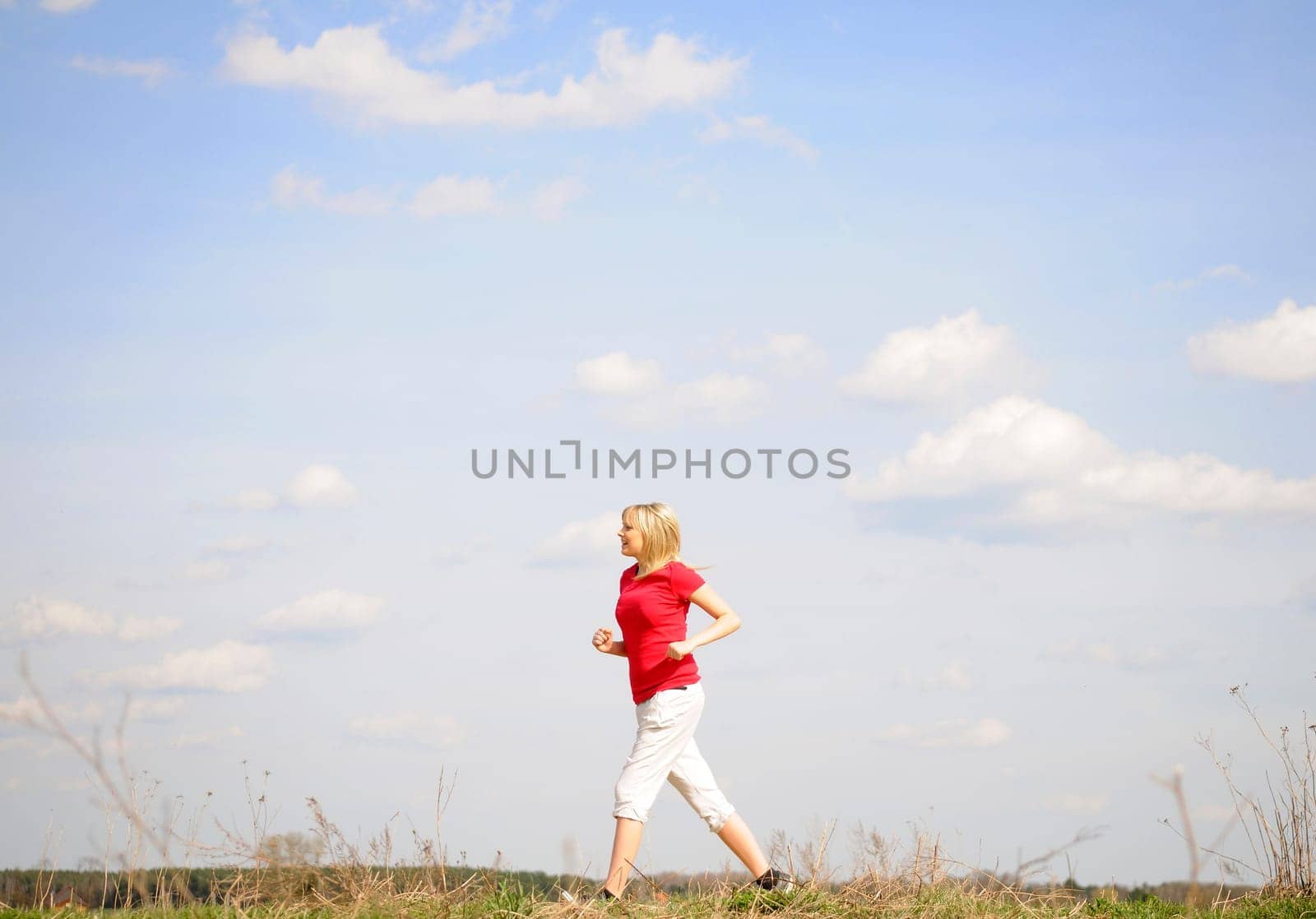 Young woman jogging on a dirt road