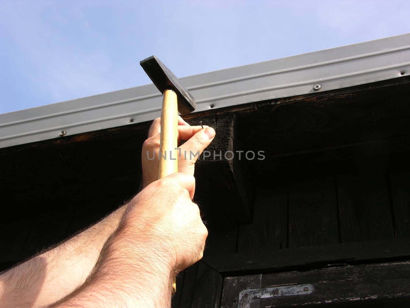 Man hammering a nail into wood with a hammer