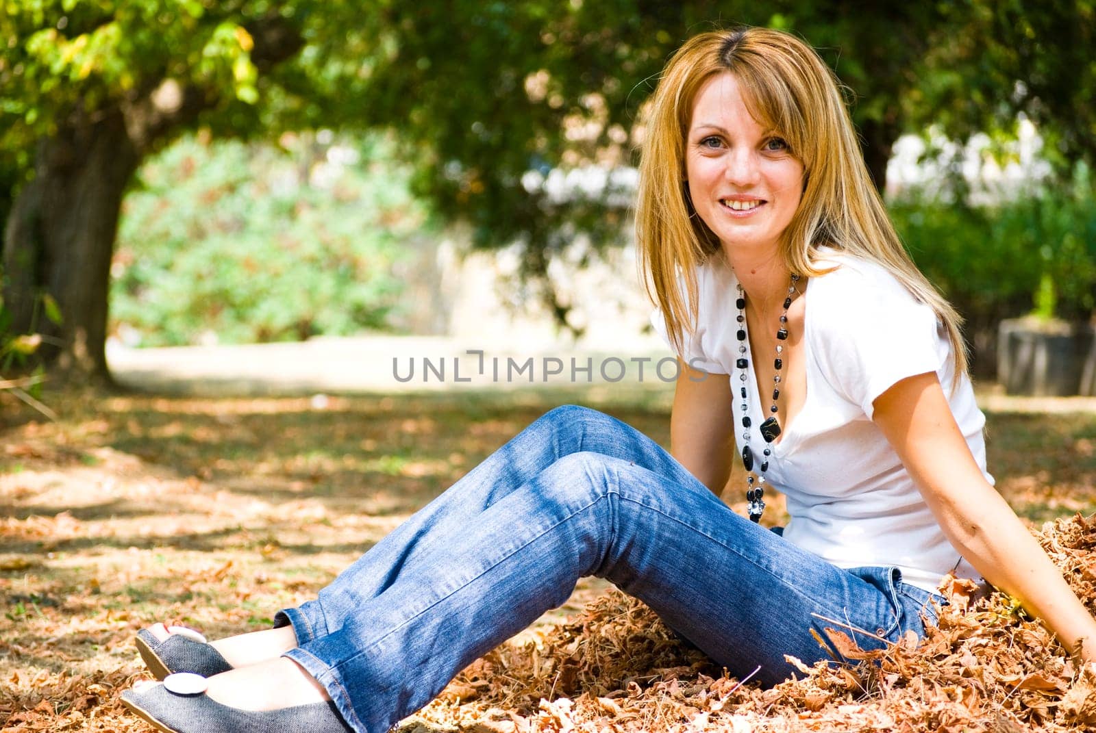 beautiful young model throwing leaves in park