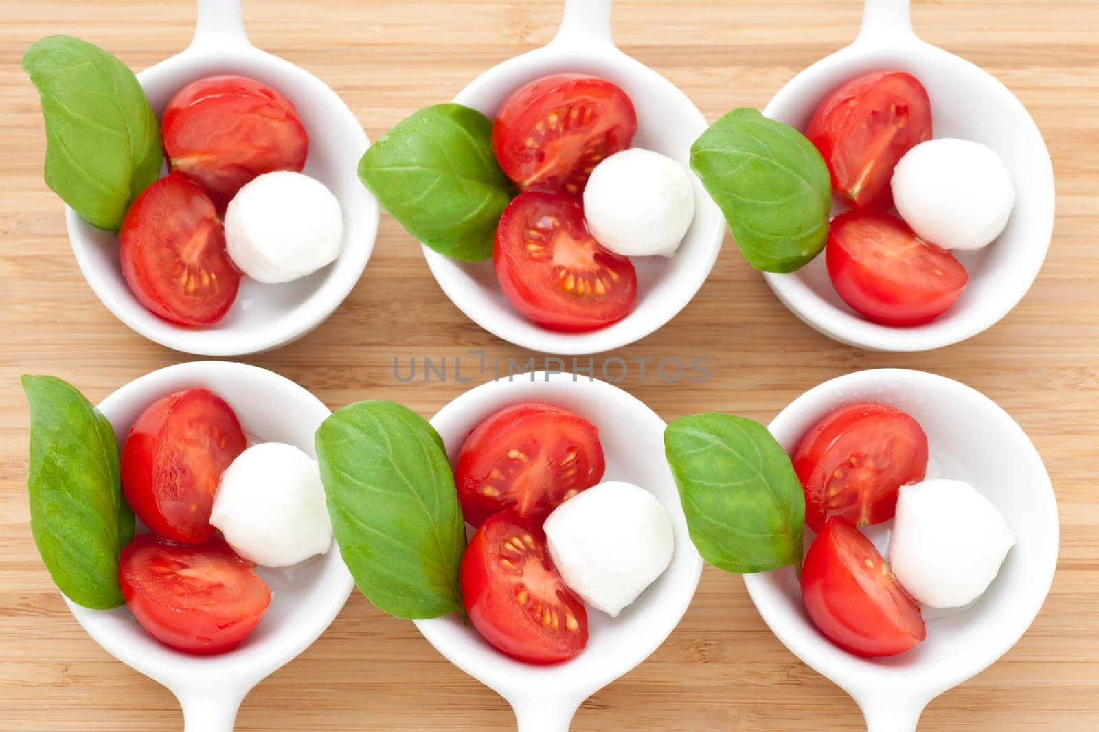 Fresh mozzarella, cherry tomato and basil appetizers photographed from above.