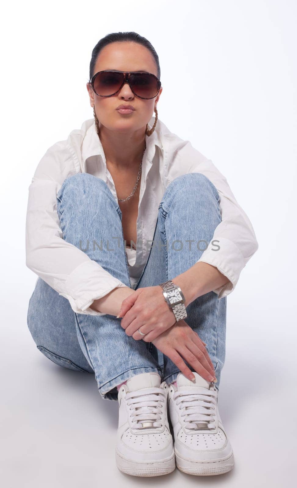 Young girl in tomboy style sit on ground - shirt and jeans