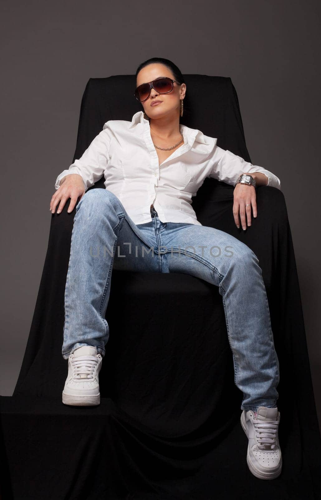 Young woman in tomboy style  sit on black chair