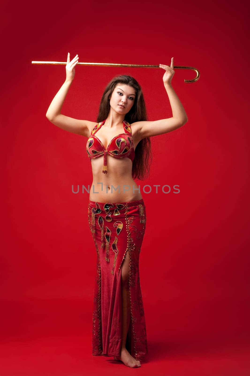 young beauty woman in red traditional arabic costume dance with cane