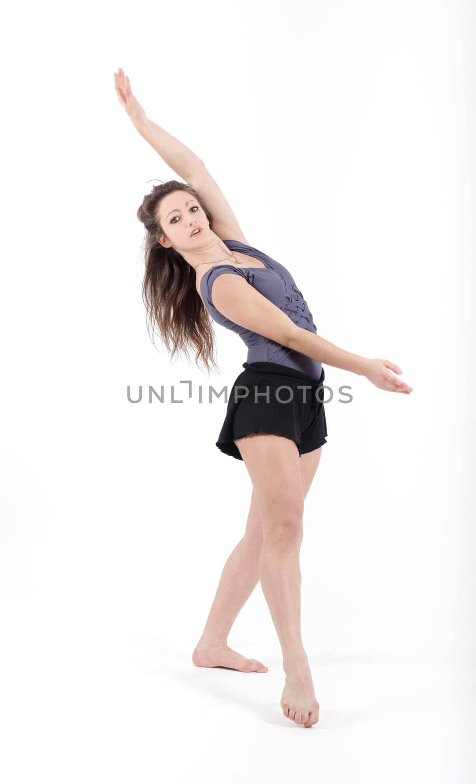 Young pretty teenage girl brunette dancing in studio with long hair