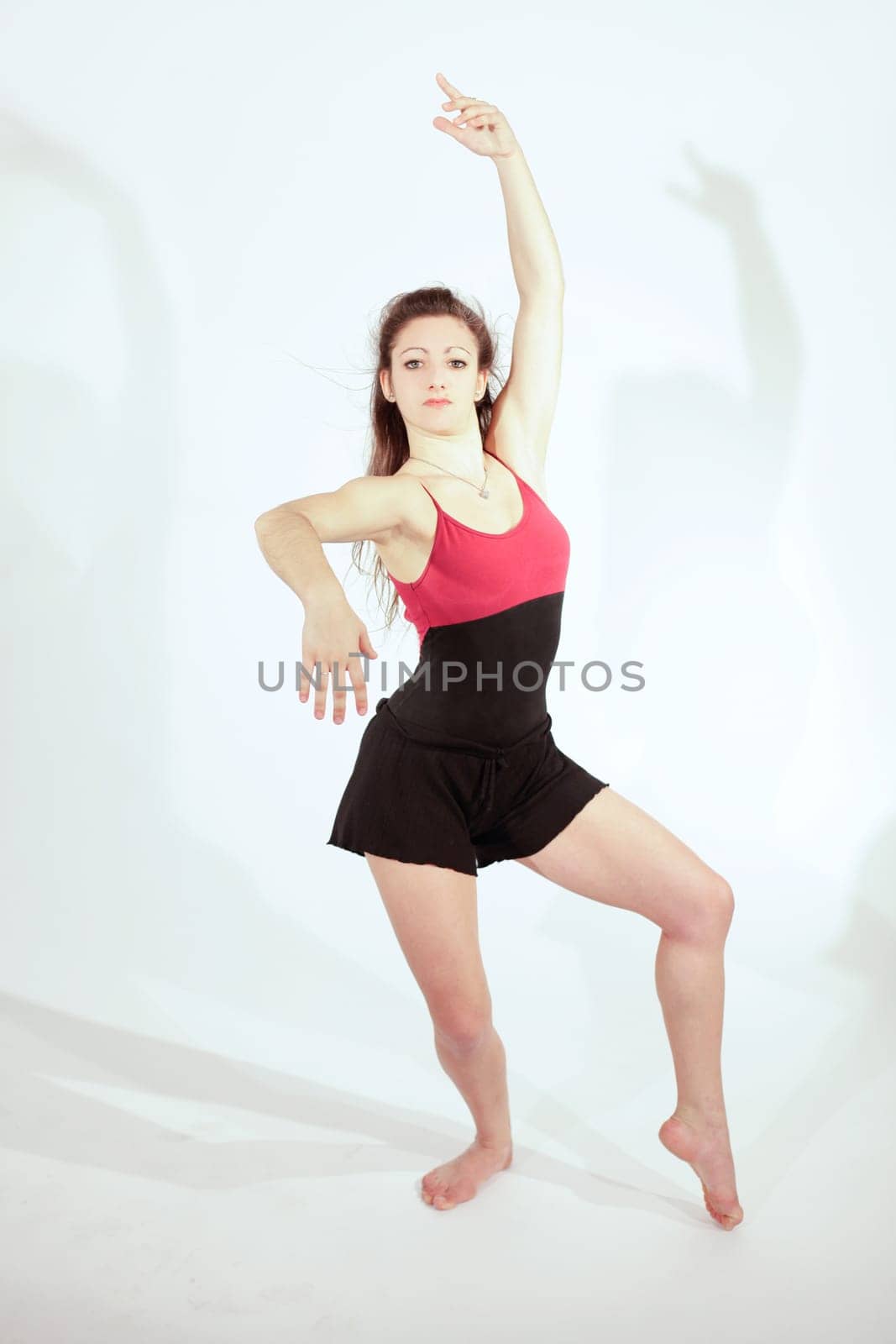 Young pretty teenage girl brunette dancing in studio with long hair