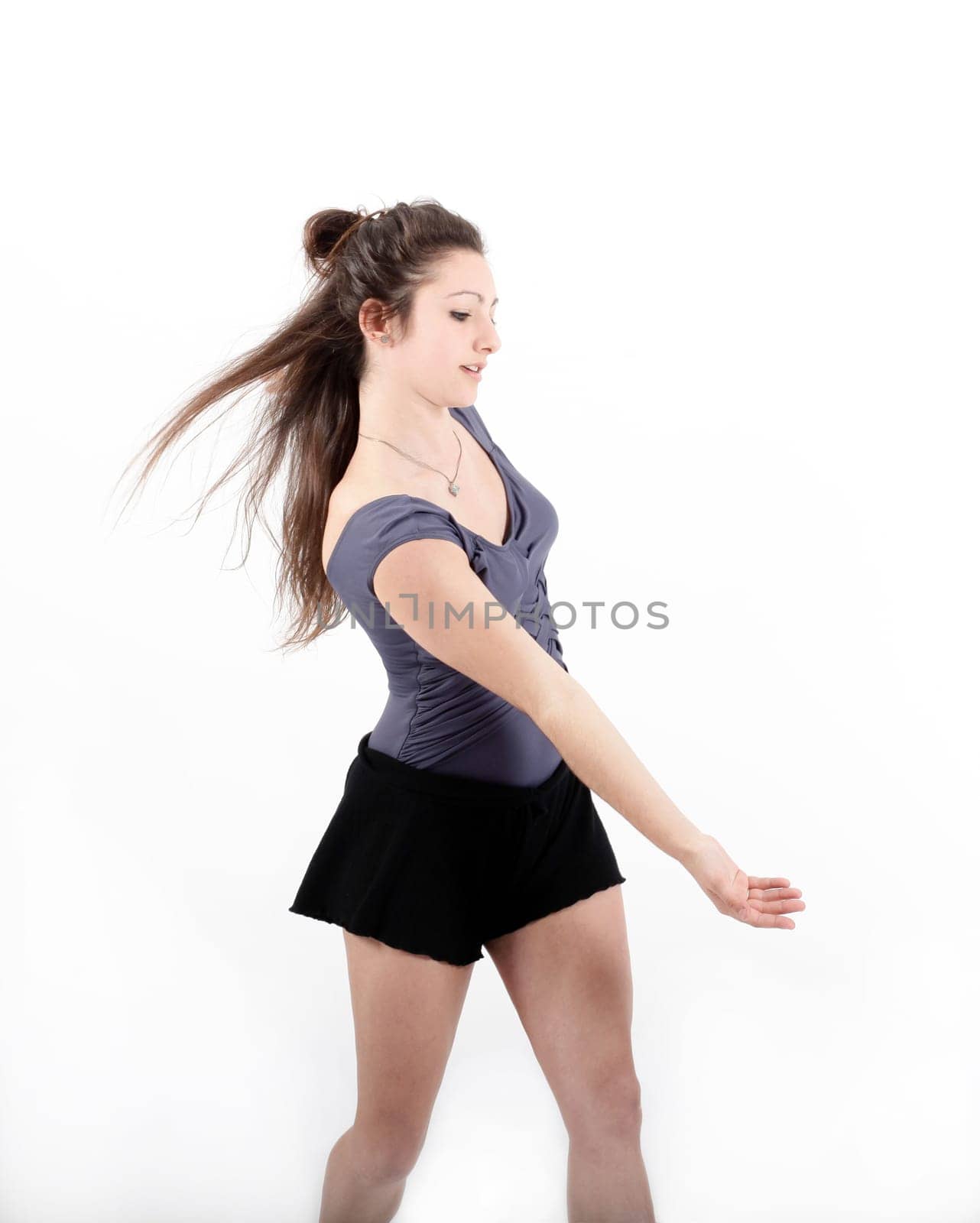 Young pretty teenage girl brunette dancing in studio with long hair