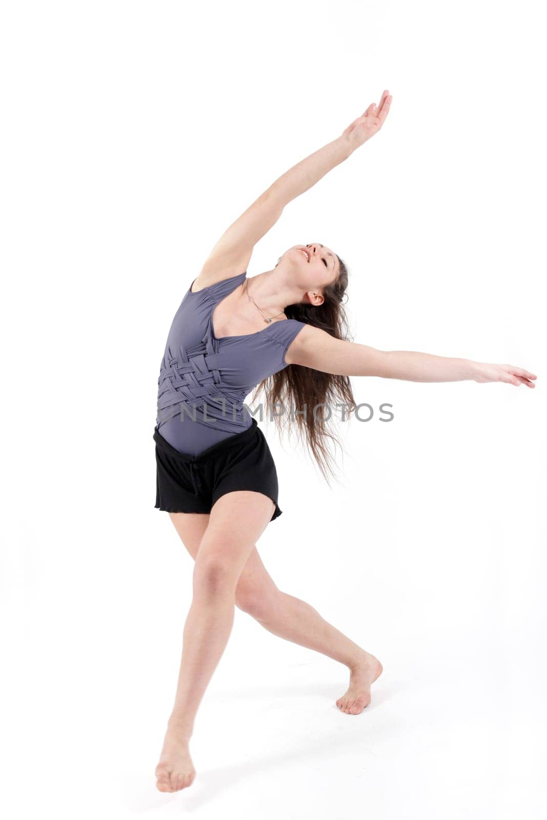 Young pretty teenage girl brunette dancing in studio with long hair