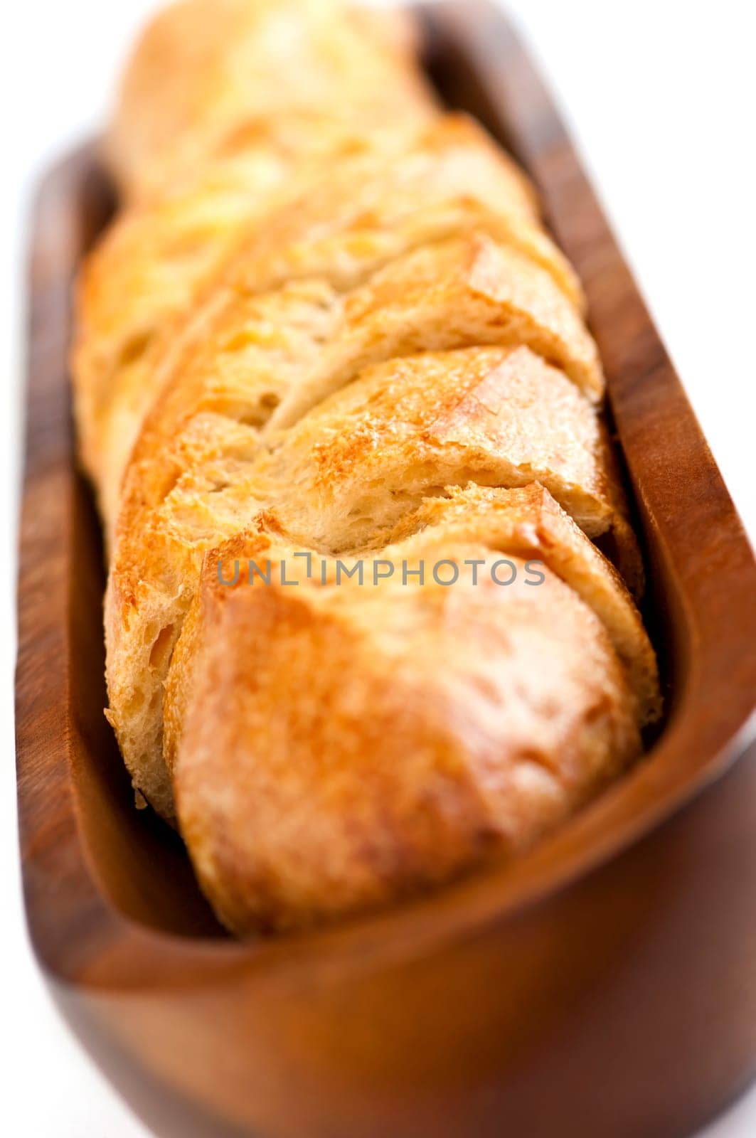 Isolated sliced baguette bread in wooden dish