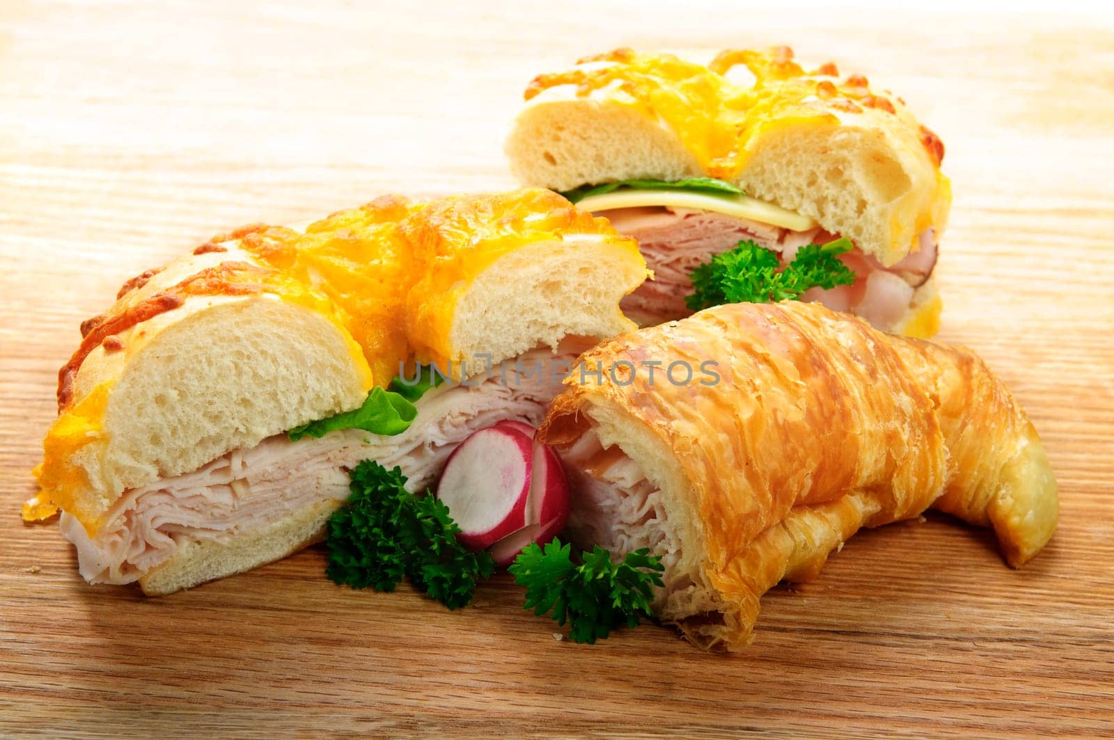 Assorted bagel and croissant sandwiches with meat and vegetables