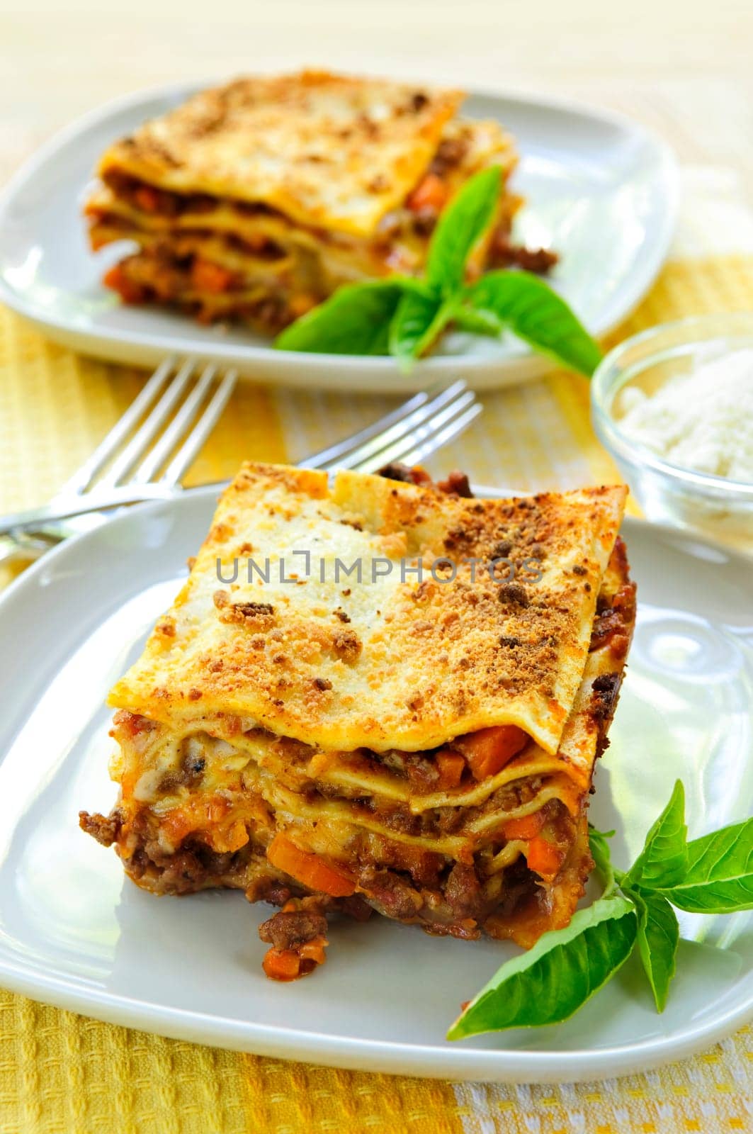 Two servings of fresh baked lasagna on plates