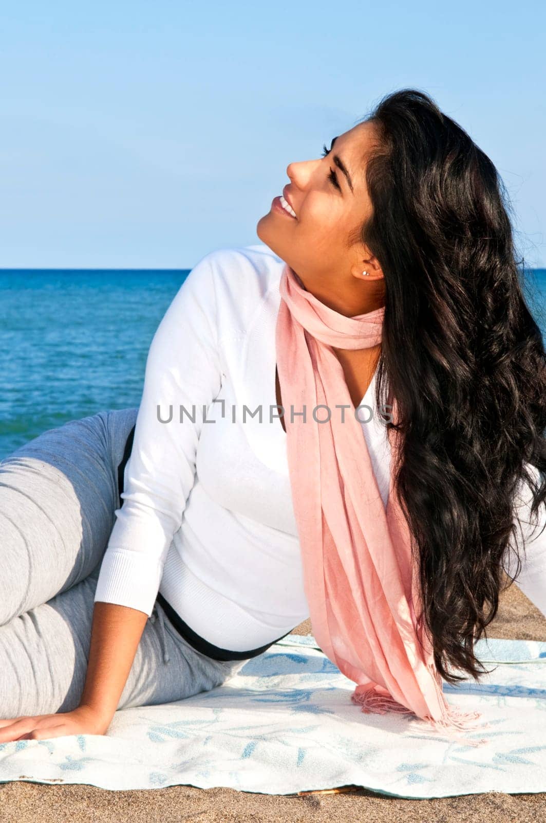 Portrait of beautiful smiling native american girl sitting at beach