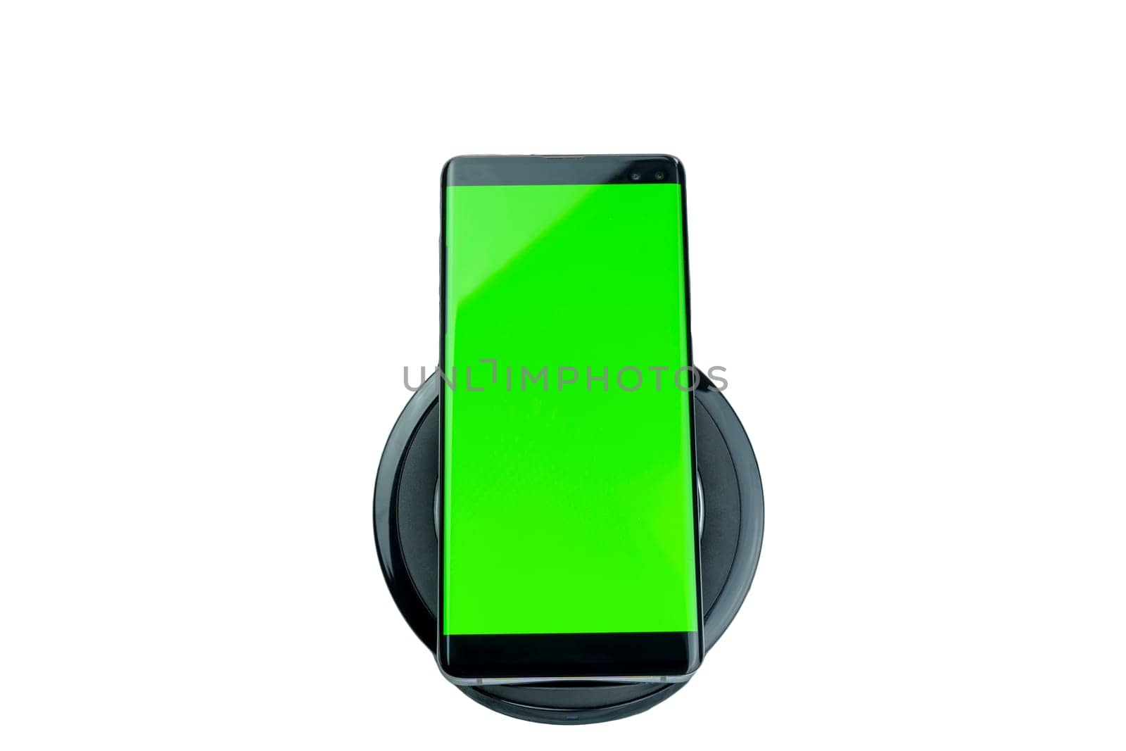 Modern smartphone with a bright green screen placed on a wireless charging pad, isolated on a white background, suitable for mockups and design presentations.