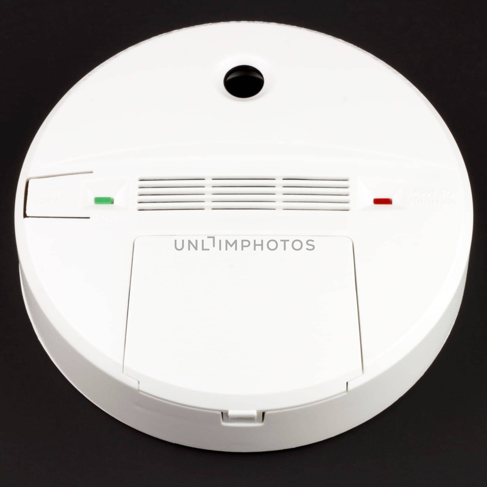 Battery powered alarm device to warn against dangerous CO buildup in indoor environments on black background.