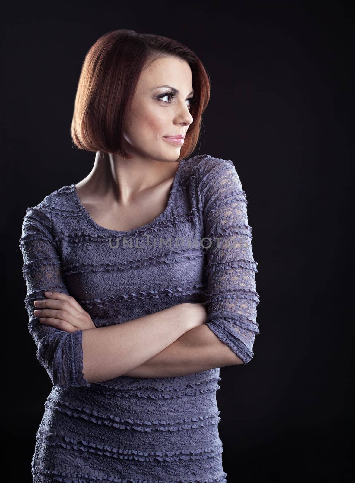 Young beauty brunette posing in grey dress on dark