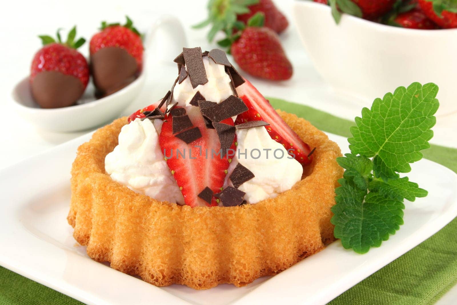 Strawberry tartlets with cream and chocolate sprinkles