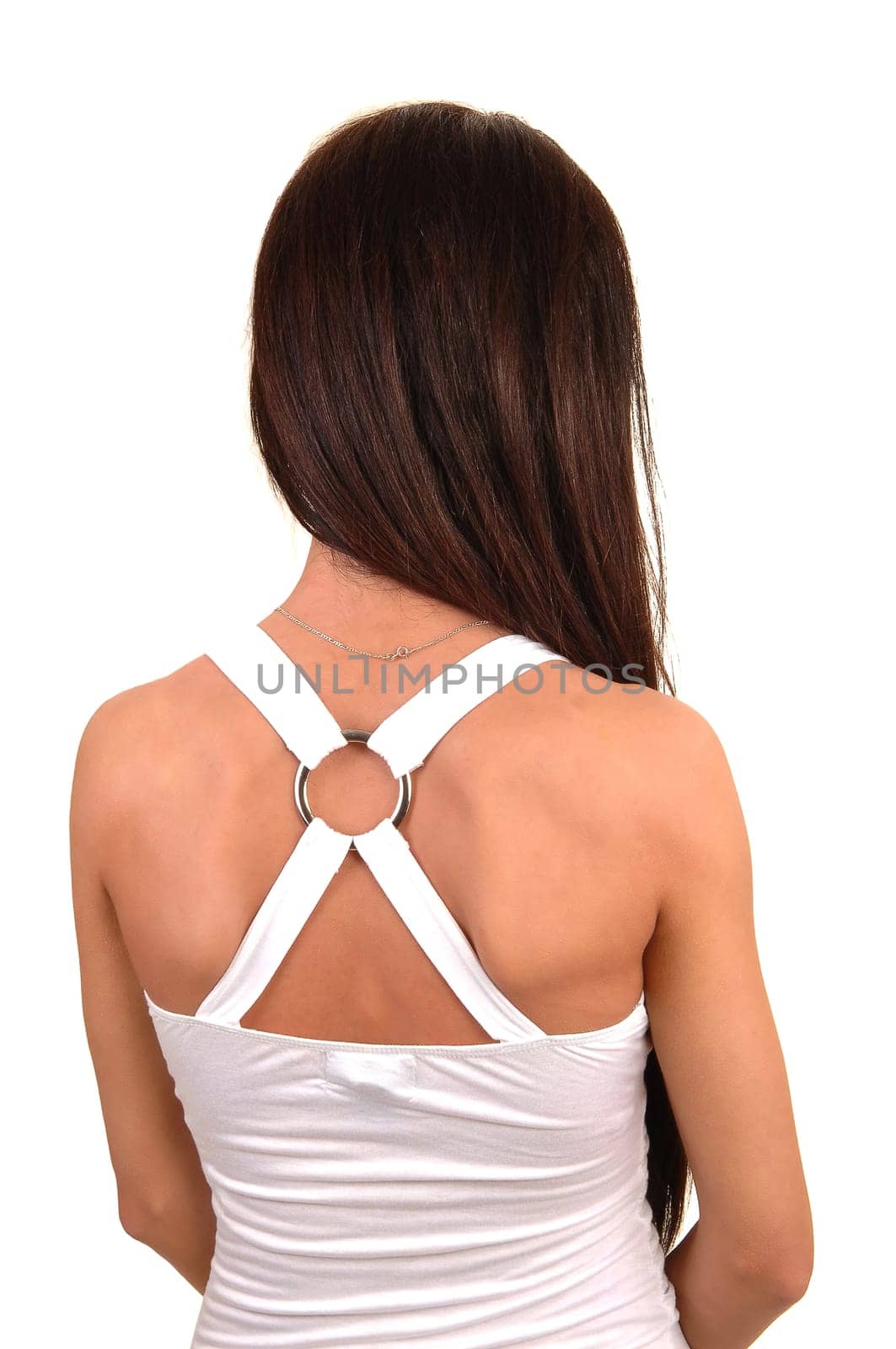 A beautiful young woman in a white blouse standing in the studio from the back  with her beautiful brunette hair, for white background.