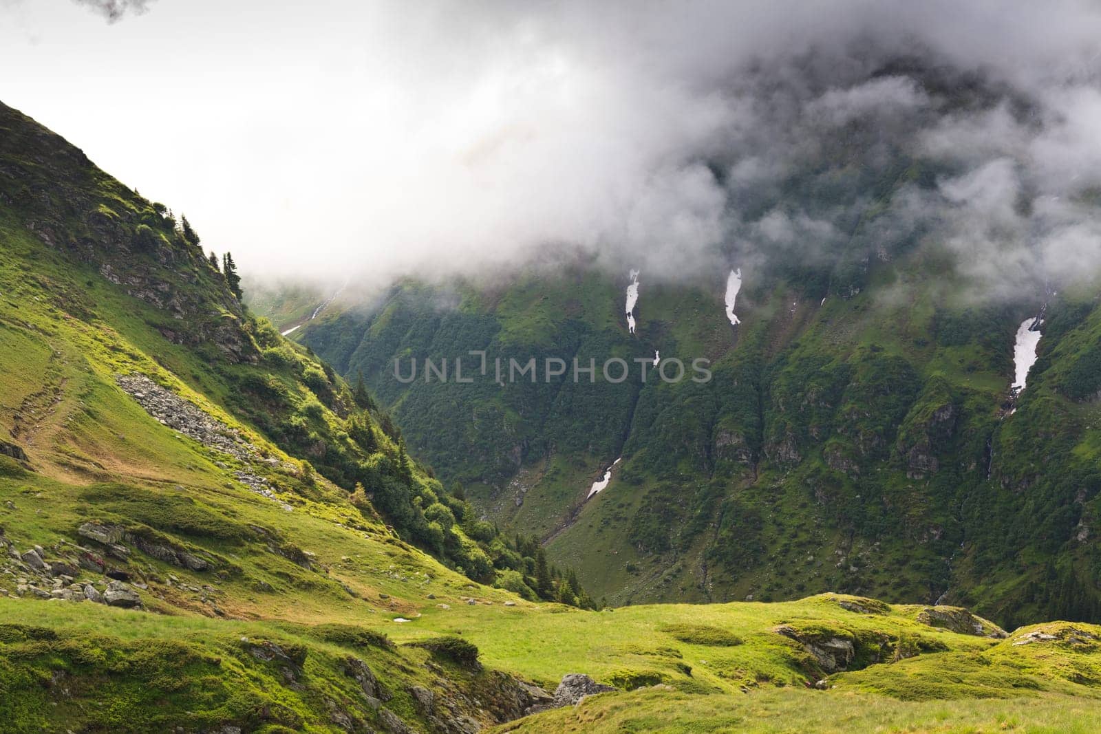 a green mountain slope and a cloudy sky