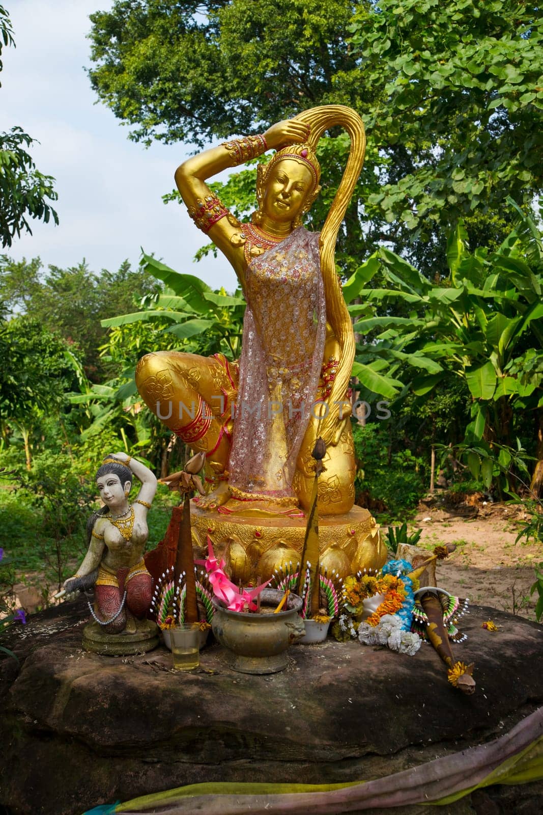 Phra Mae Thorani,the buddhist godness of earth - a statue in a remote temple area in Isaan region of Thailand