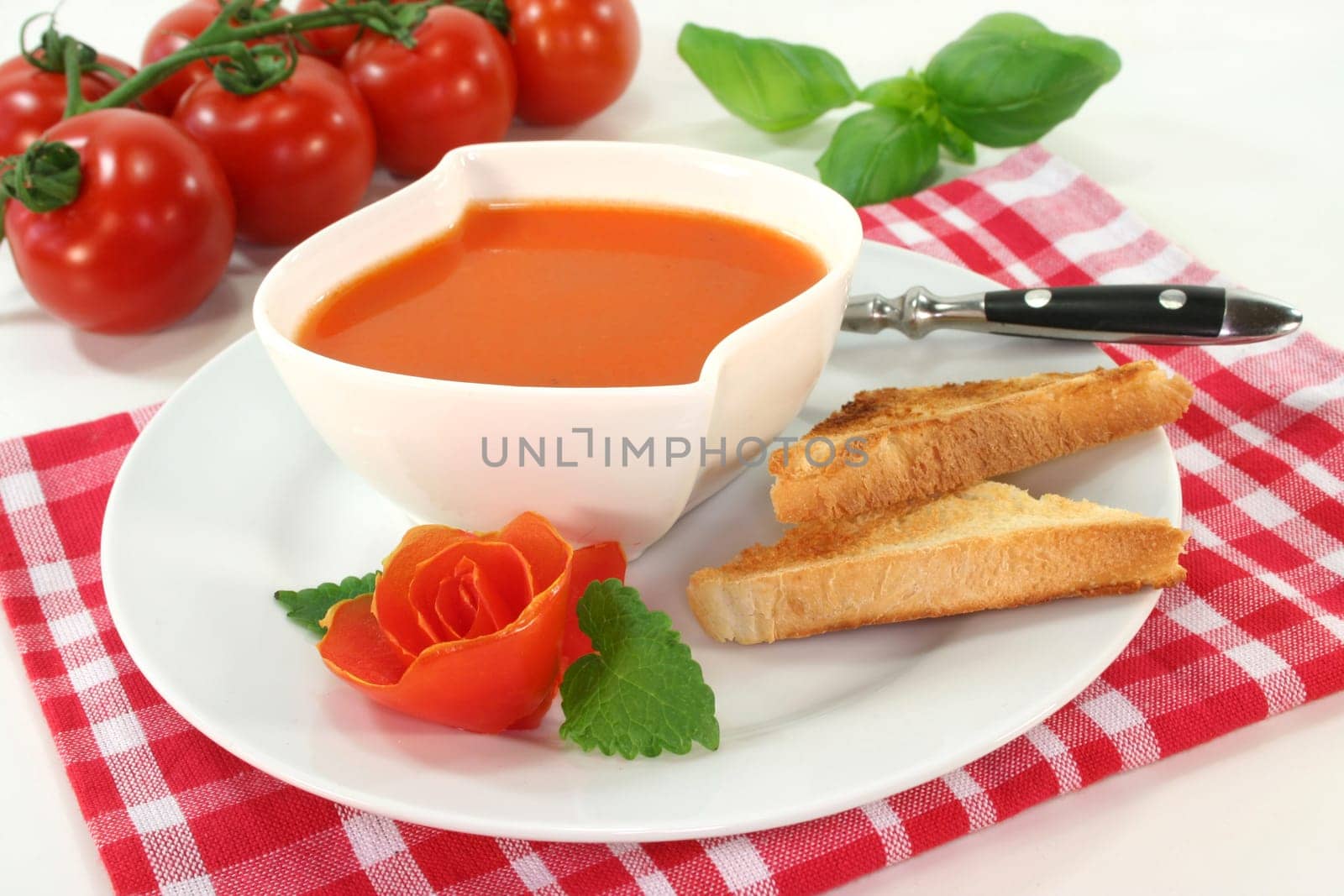 a bowl of tomato cream soup with toast