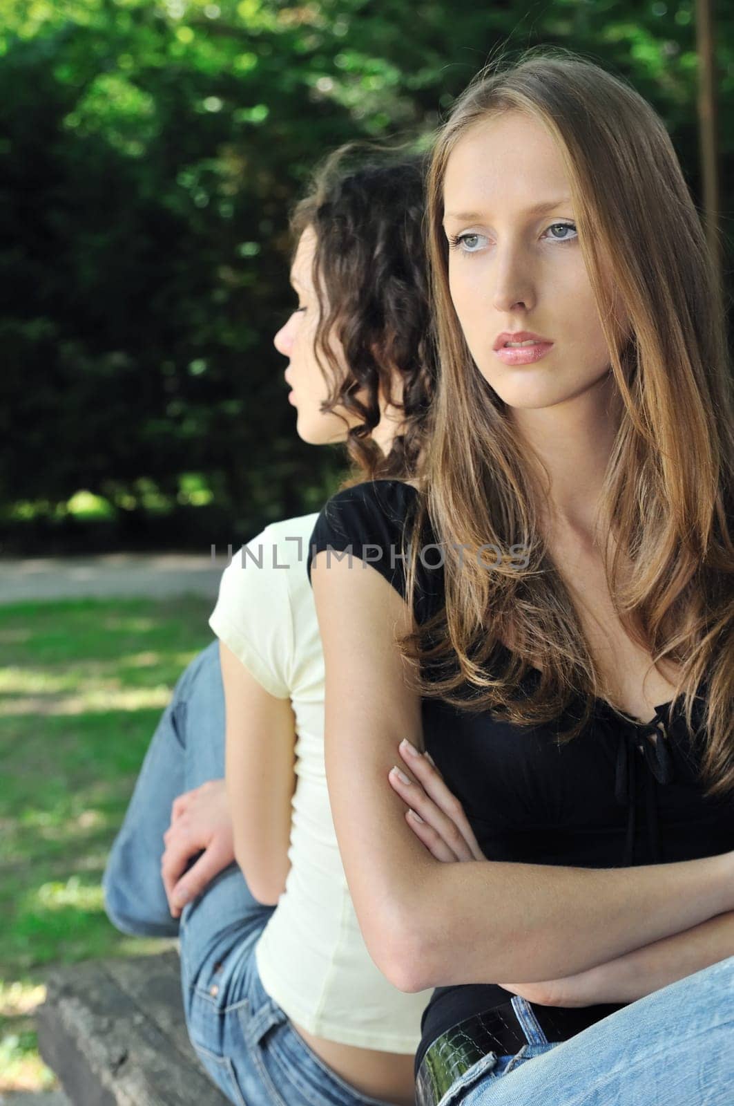 Friends outdoors series - two teenage girls are in conflick and do not speak with each another