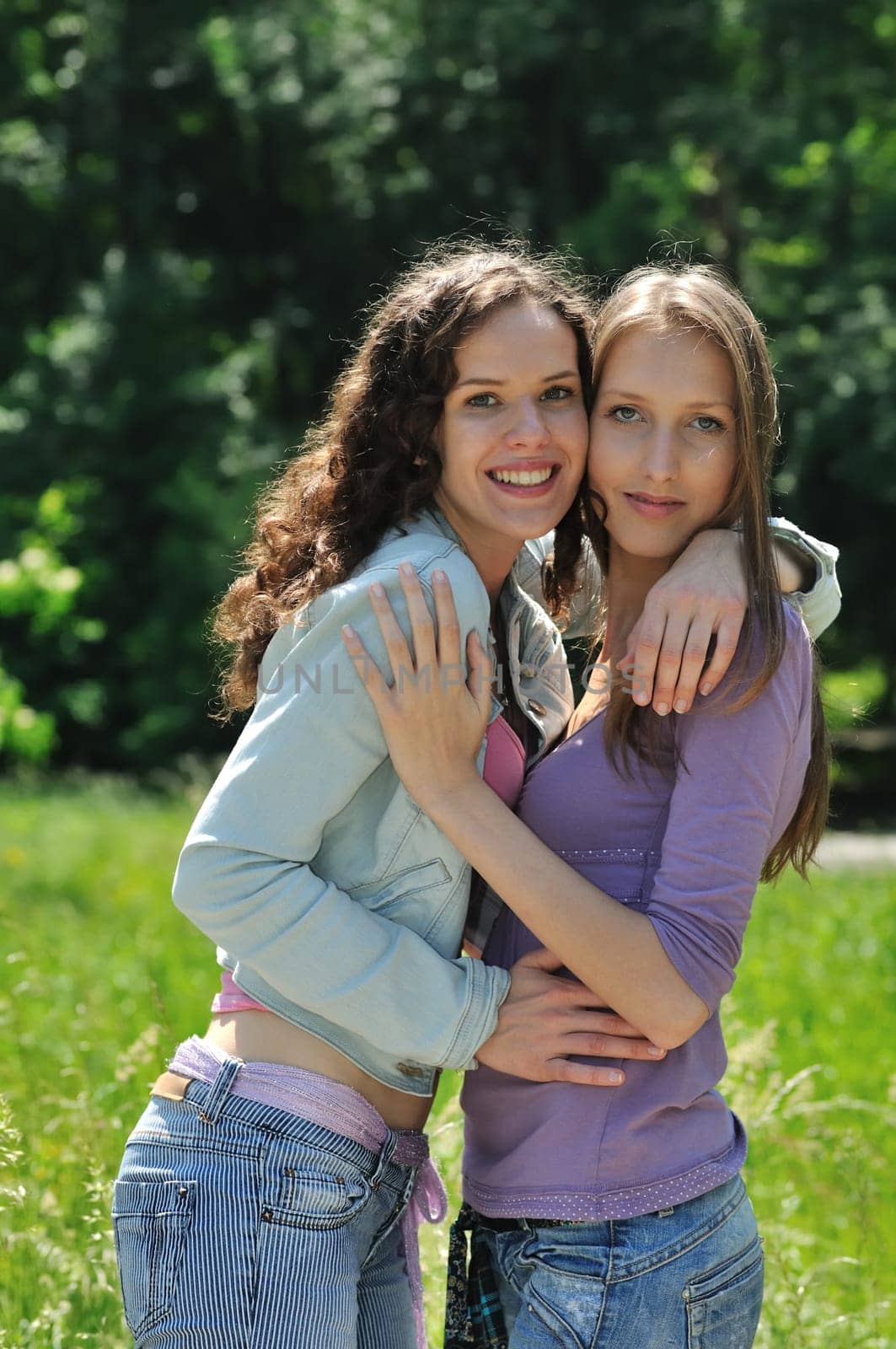 Two happy teenage friends embracing together  are outdoors in nature