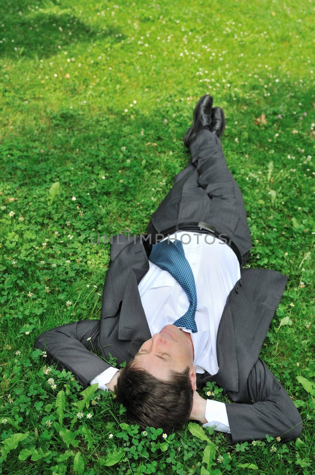 Senior people series - mature business man lying in green grass and relaxing