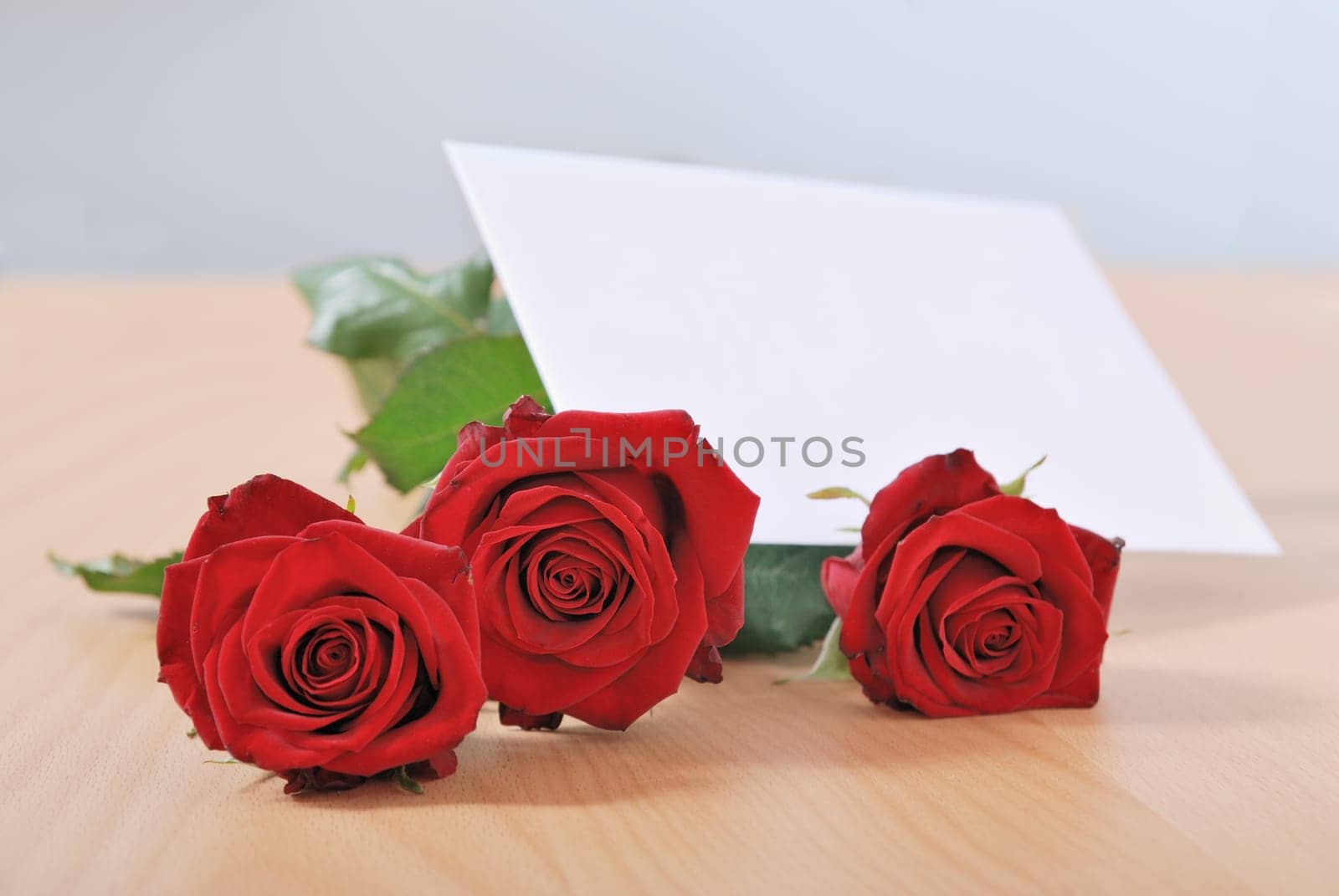 Love message on table - red roses with envelope