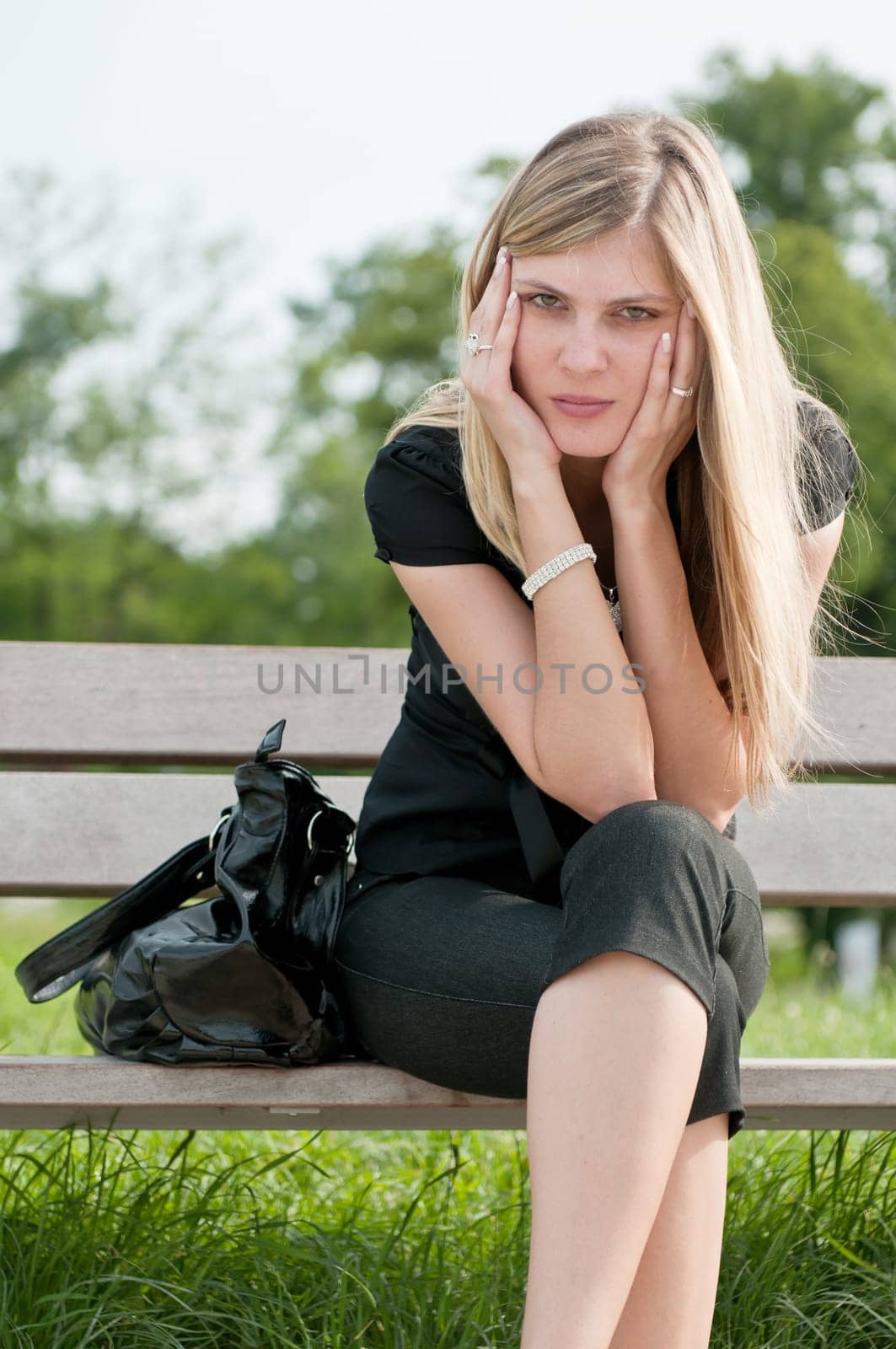 Young worried beautiful woman siting on bench - head in hands