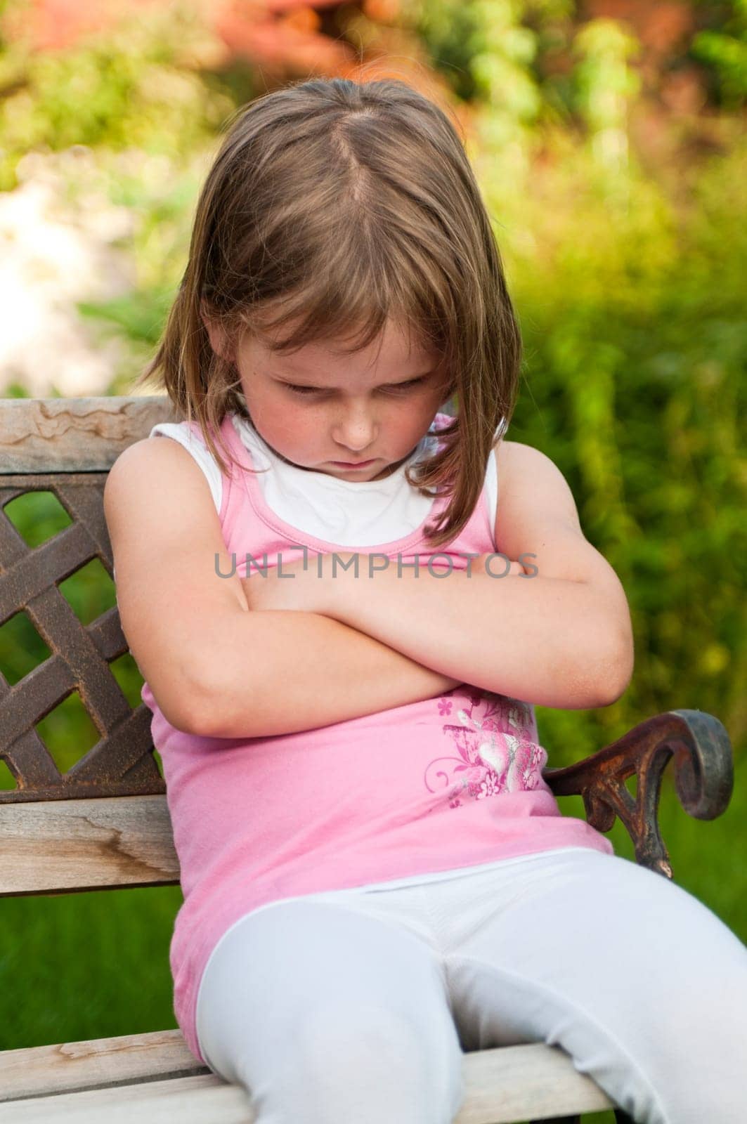 Outdoors portrait of small cute girl with offended look