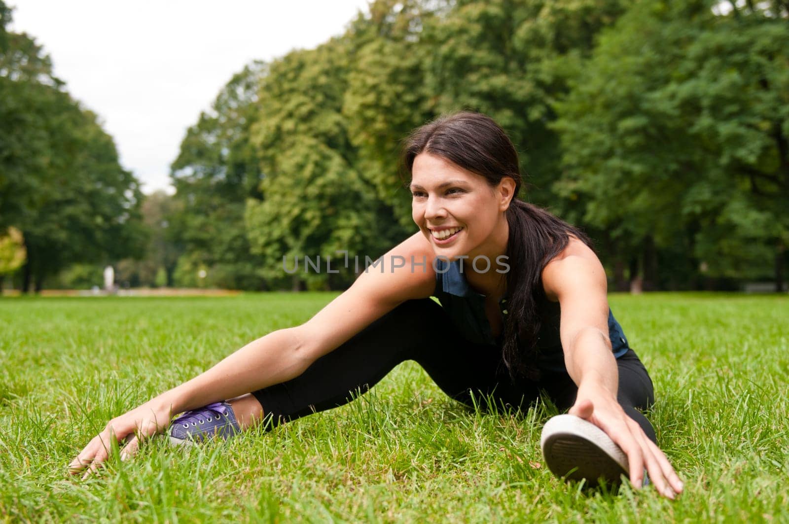 Relax - sportswoman sitting in grass