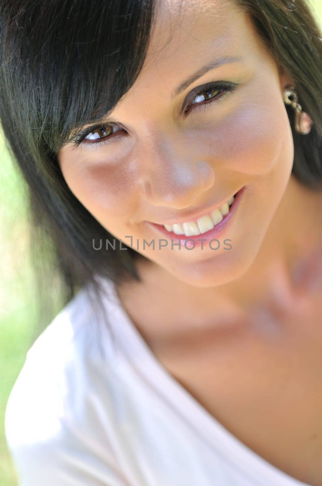 Portrait of young beautiful smiling woman with black hair - outdoors