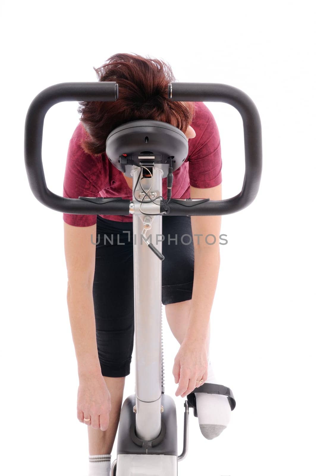 Tired senior woman on spinning bicycle - isolated