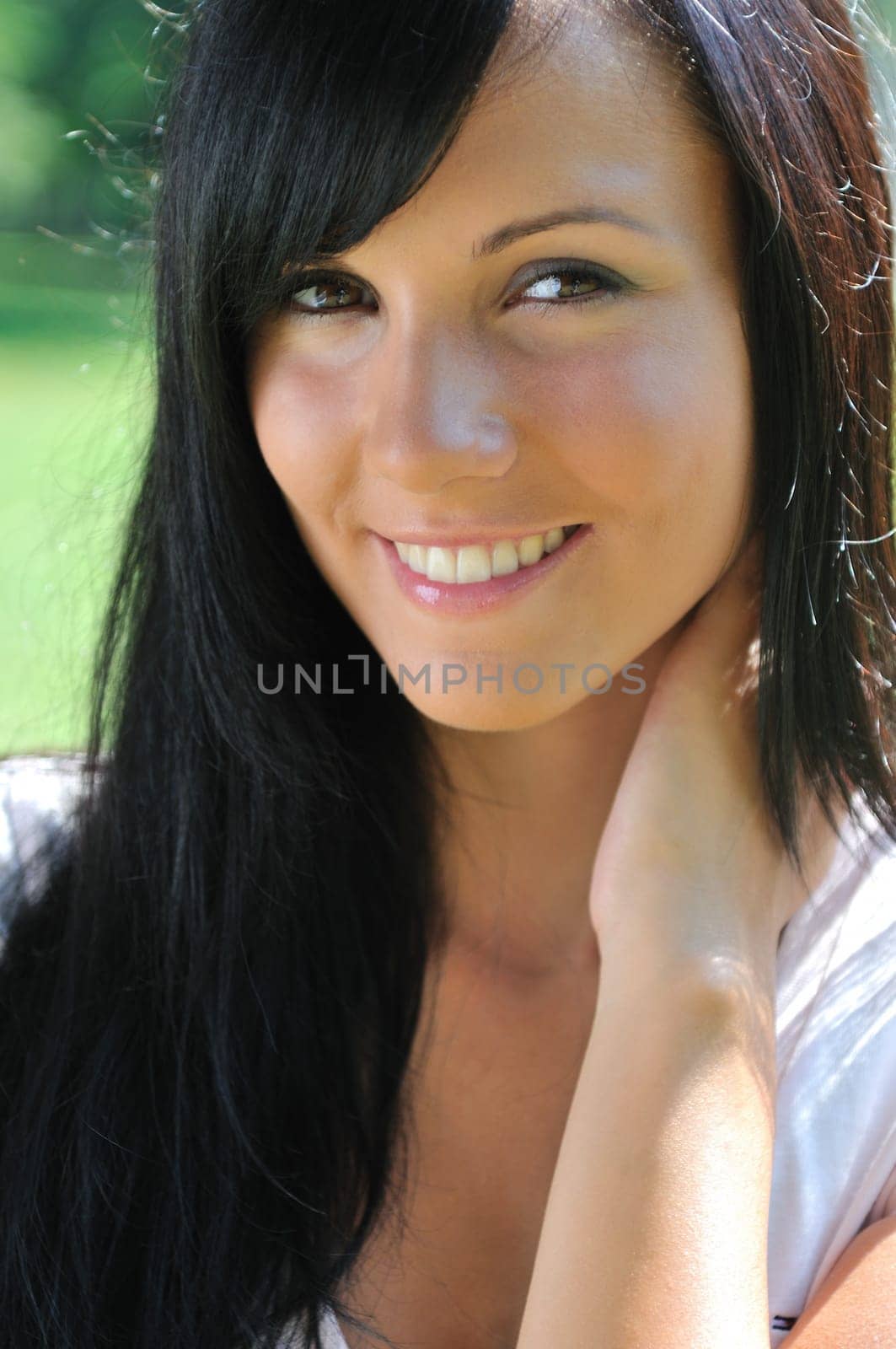Portrait of young beautiful smiling woman with black hair - outdoors