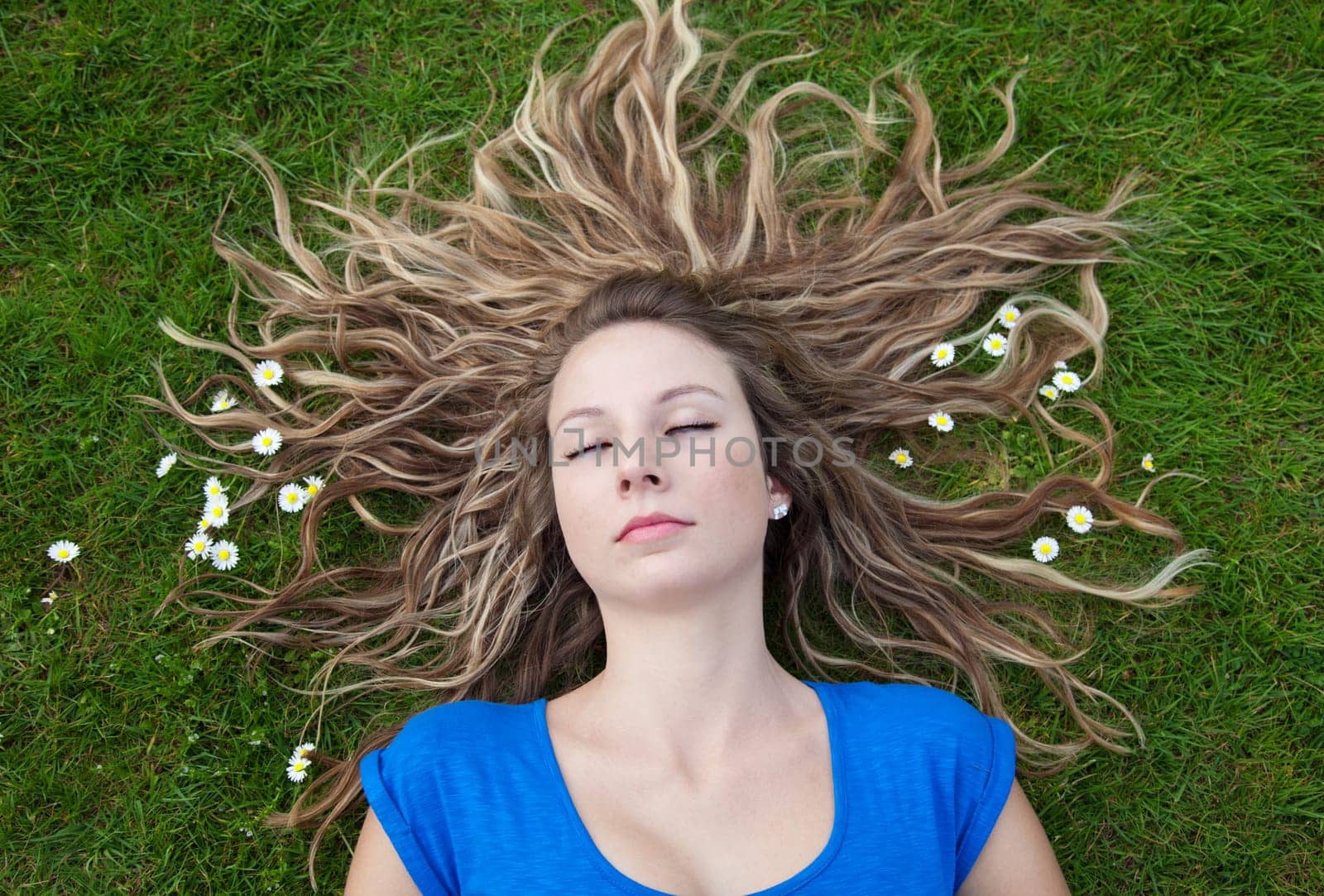 Sleeping beauty with her hair spread out on grass