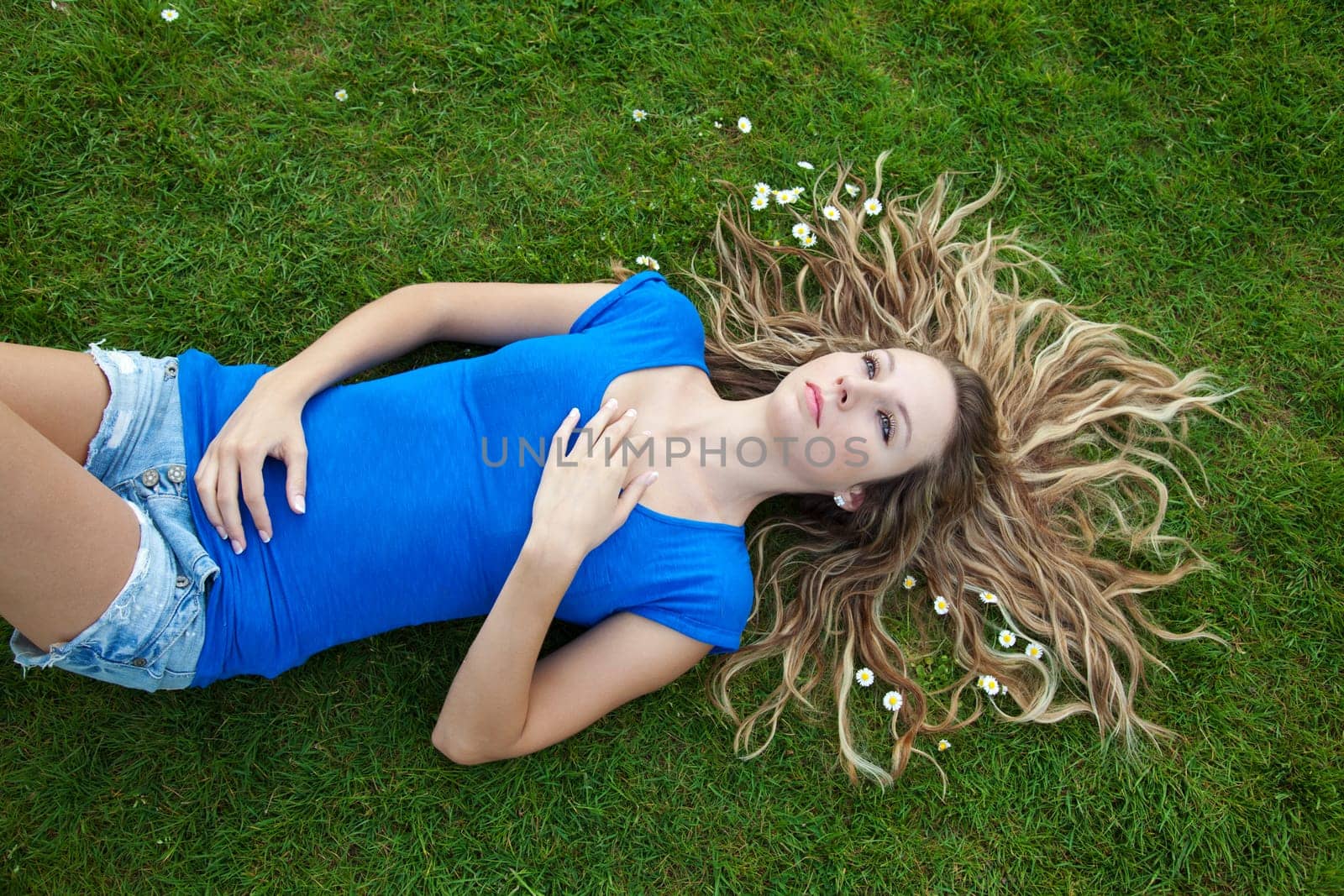 Young beautiful woman lying in park