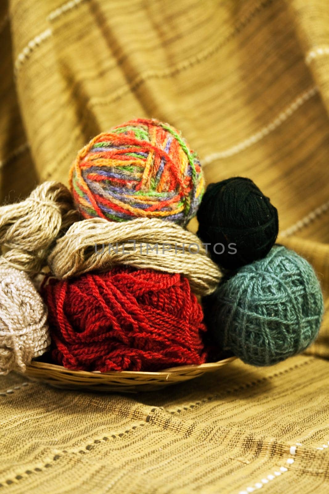 Balls of colored yarn for hand knitting in a decorative basket