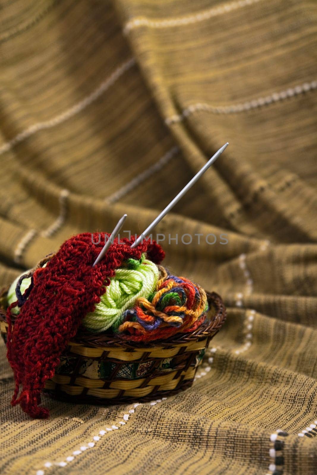 Balls of colored yarn for hand knitting in a decorative basket